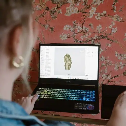 specialist controleert digitaal 3D model van zwangerschapsbeeldje op computerscherm